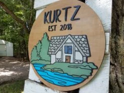 Round Personalized Name And Established Date Sign With Raised Lettering And Cabin Scene -The Farmer’s Wife WI Deals Store Cabin with Water3