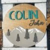 Round Personalized Nursery Name Sign With Raised Lettering And Mountain Scene